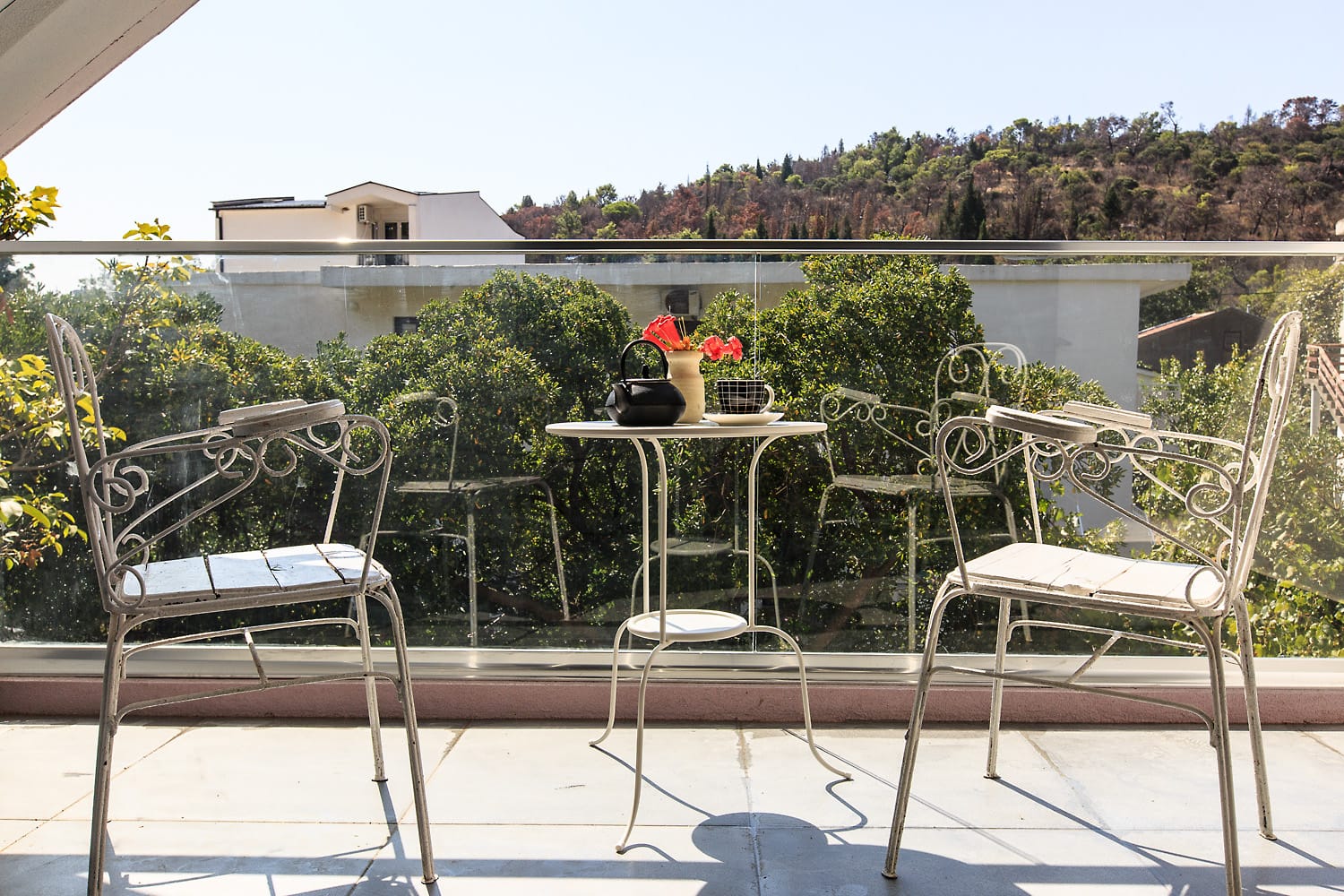 Cozy balcony with wrought-iron furniture and mountain views in a house in Sutomore, Montenegro. An ideal place to relax.