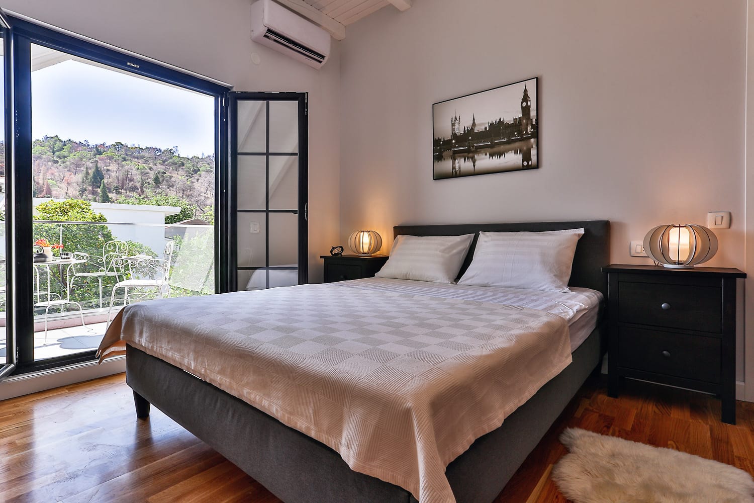 Bedroom in a house in Sutomore, Montenegro: double bed, parquet flooring, access to a terrace with mountain and greenery views.