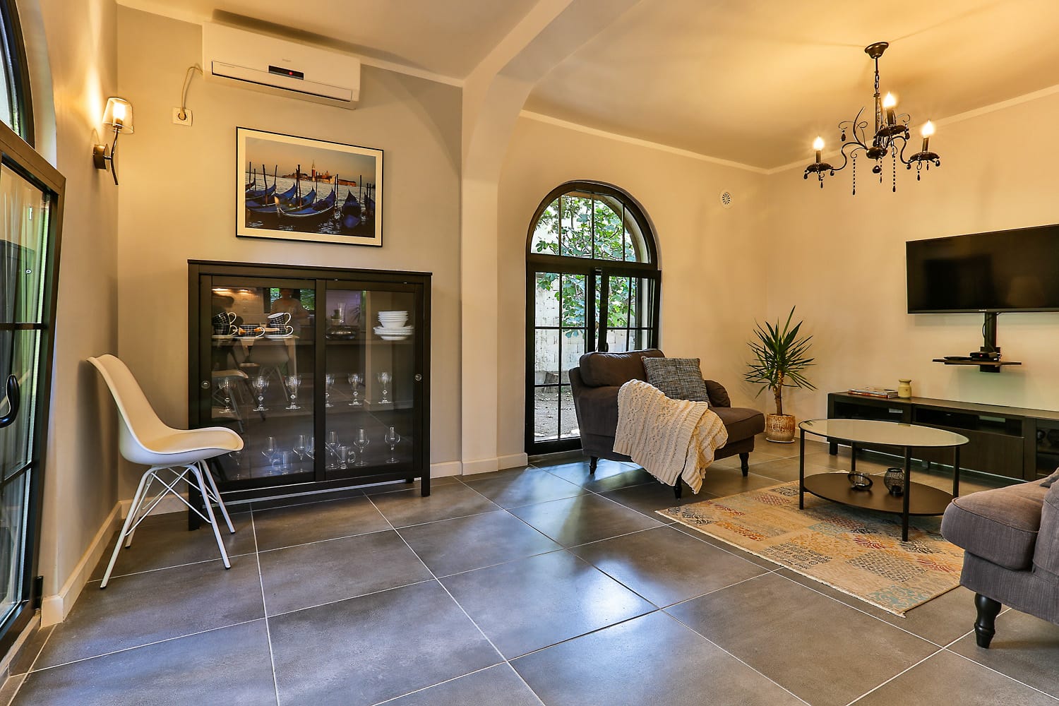 Cozy living room in a house in Sutomore, Montenegro: modern furniture, arched windows, tiled floor, and stylish interior.