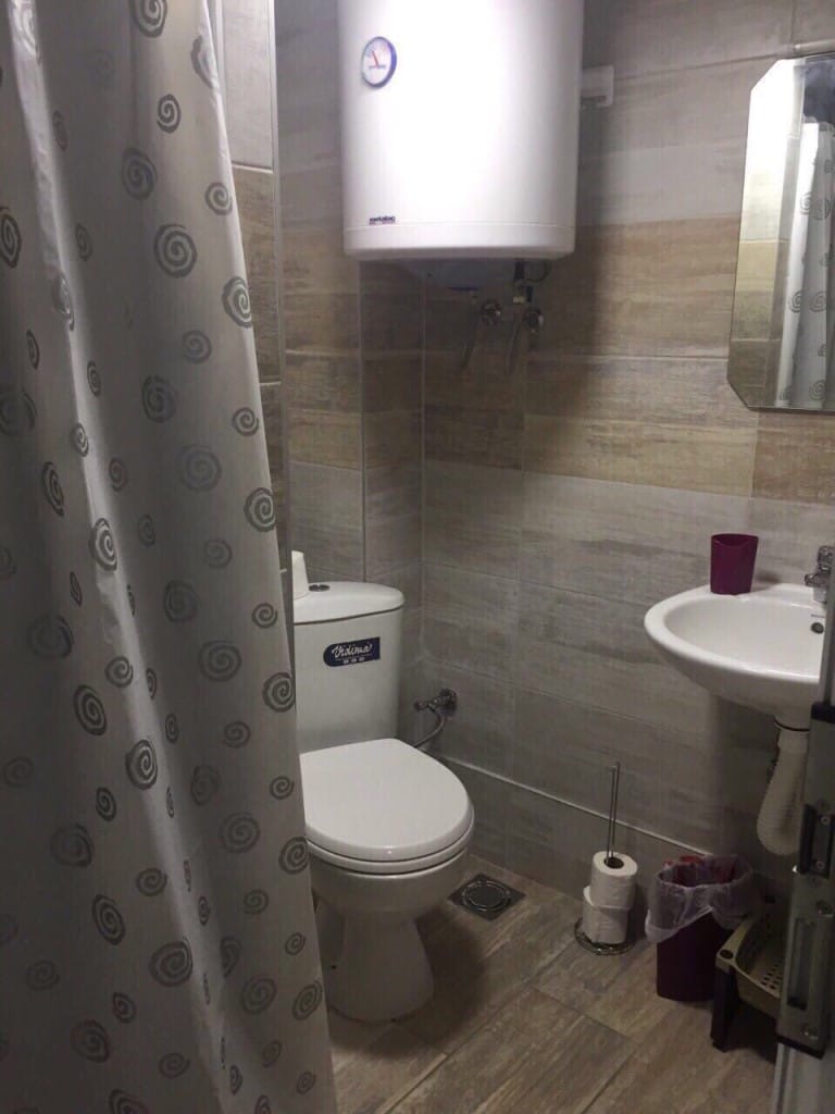 Bathroom in a mini-hotel, Rafailovici, Montenegro: tile, Vidima fixtures, water heater, and shower curtain.