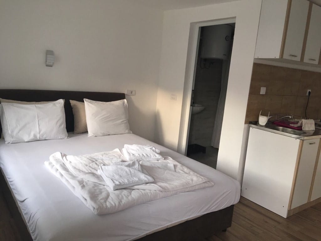 Bedroom in the Rafailovici mini-hotel, Montenegro: double bed, kitchenette, and private bathroom in the room.