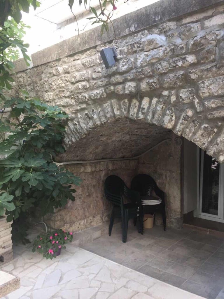Cozy terrace with a stone arch and garden furniture at a mini-hotel, Rafailovici, Montenegro.