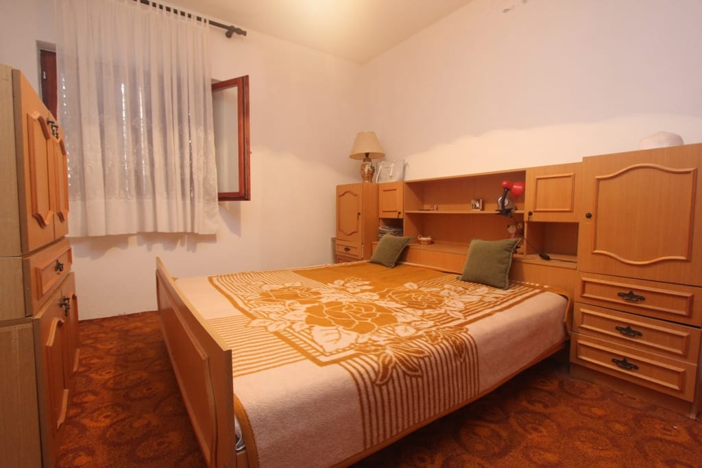 Bedroom with a double bed and wooden furniture in a house, Orahovac, Montenegro.