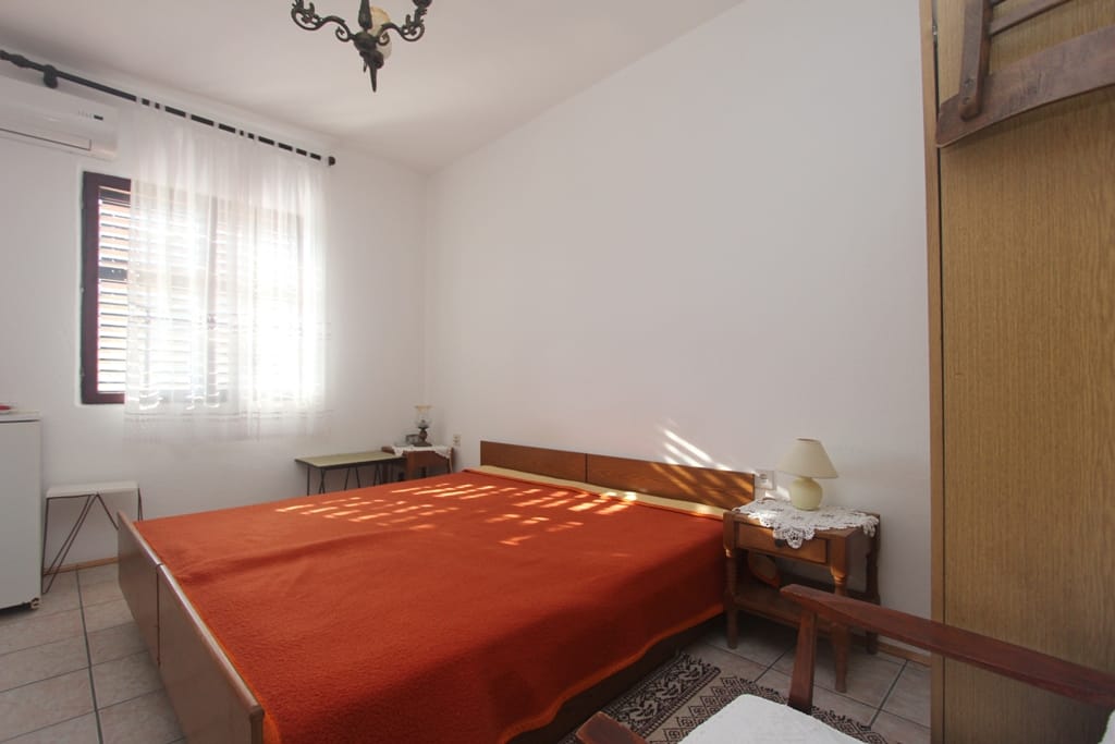 Bedroom with a double bed in a house in Orahovac, Montenegro: a bright room with air conditioning and wooden furniture.