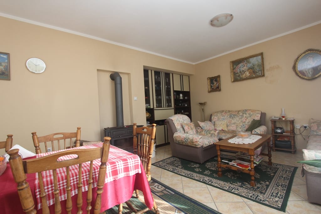 Cozy living room with a fireplace and dining area in a house for sale, Orahovac, Montenegro: classic furniture and decor.