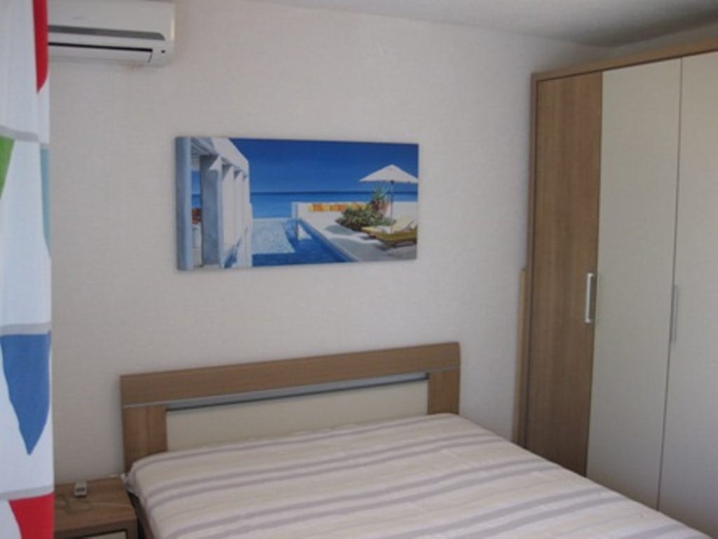Bedroom in a house in Sutomore, Montenegro: double bed, modern wardrobe, air conditioner, and a painting on the wall.