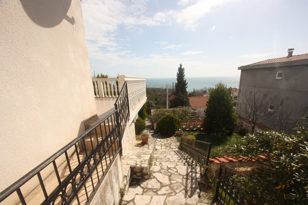 Terrace with balustrade and sea view at a house in Sutomore, Montenegro: stone staircase and landscaped grounds.
