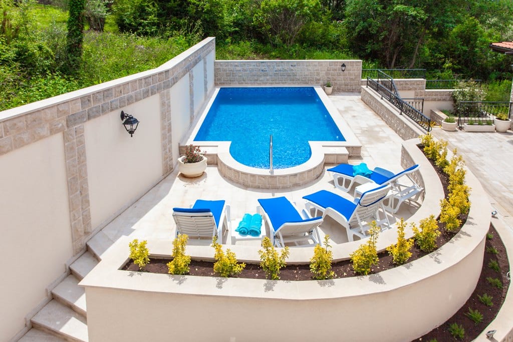 Private pool with sun loungers on the apartment terrace in Kamenovo, Montenegro, with natural stone finishes.