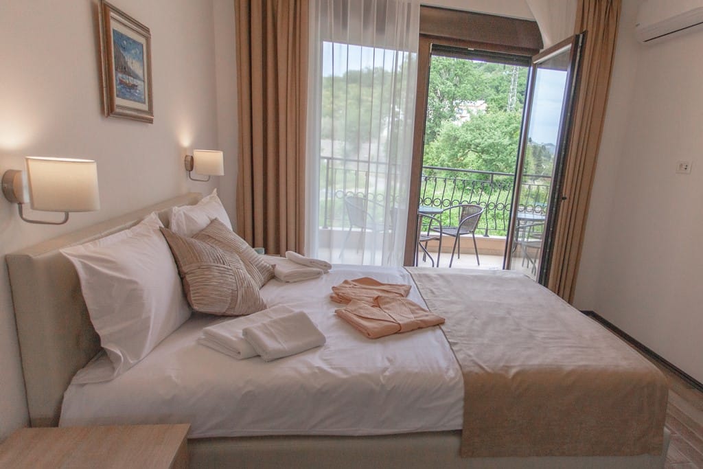 Cozy bedroom with a double bed and access to the balcony in the Kamenevo apartments, Montenegro.
