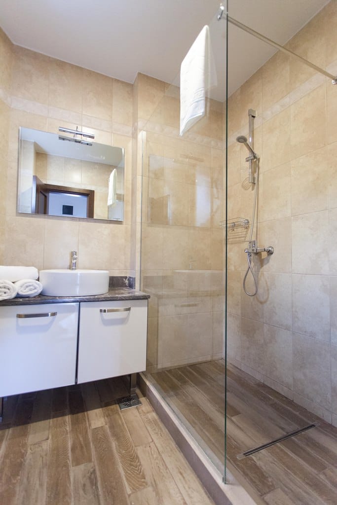 Modern bathroom with a shower cabin in an apartment, Kamenovo, Montenegro: white vanity, vessel sink, and tile.