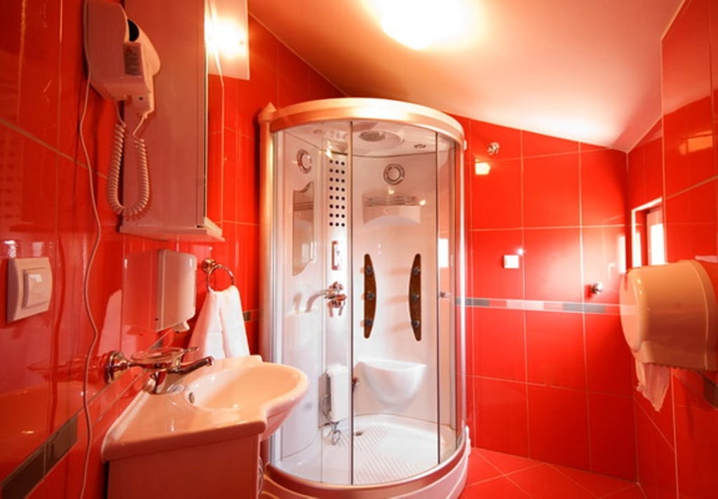 Bathroom with a shower cabin and red tiles in a mini-hotel, Bijela, Montenegro.