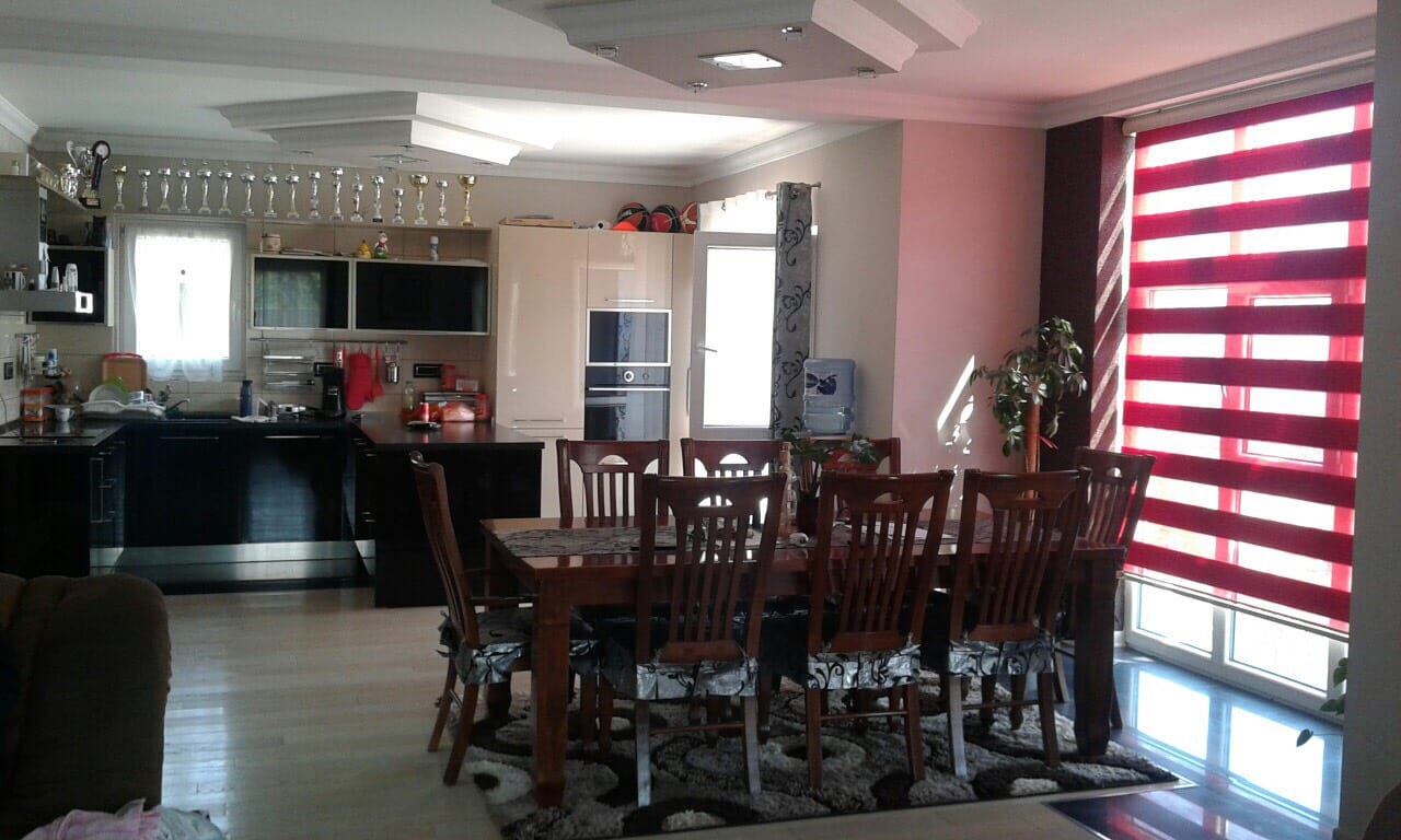 Spacious kitchen-dining room with dark cabinetry and a dining area in a villa in Sutomore, Montenegro.
