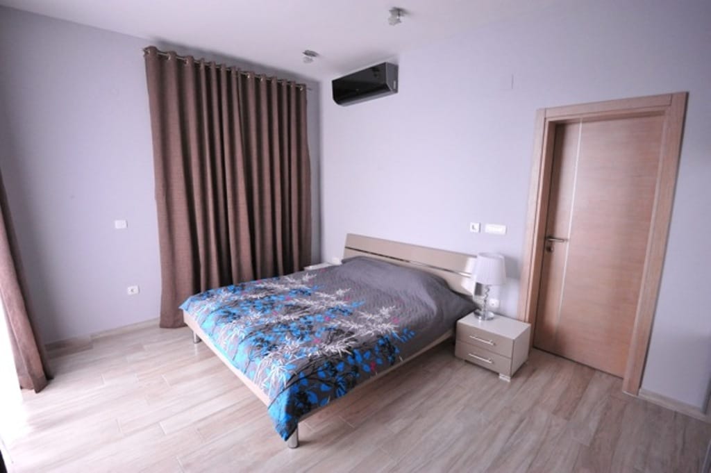 Bright bedroom with a double bed in an apartment, Dobrota, Montenegro: modern interior, air conditioner.