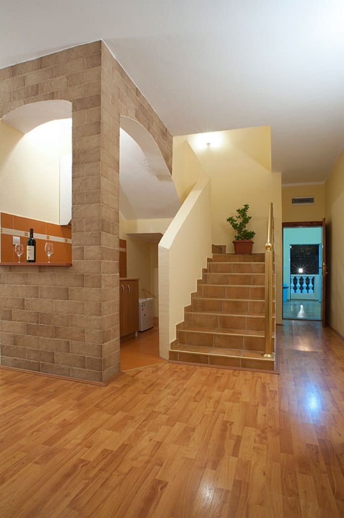 Living room interior with staircase and brick finishes in a hotel, Buljarica, Montenegro. Wooden floor and cozy atmosphere.