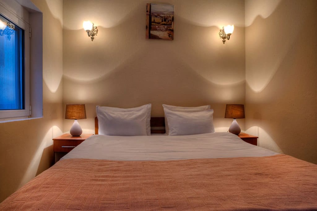 Cozy bedroom with a double bed and bedside lamps in a hotel, Buljarica, Montenegro.