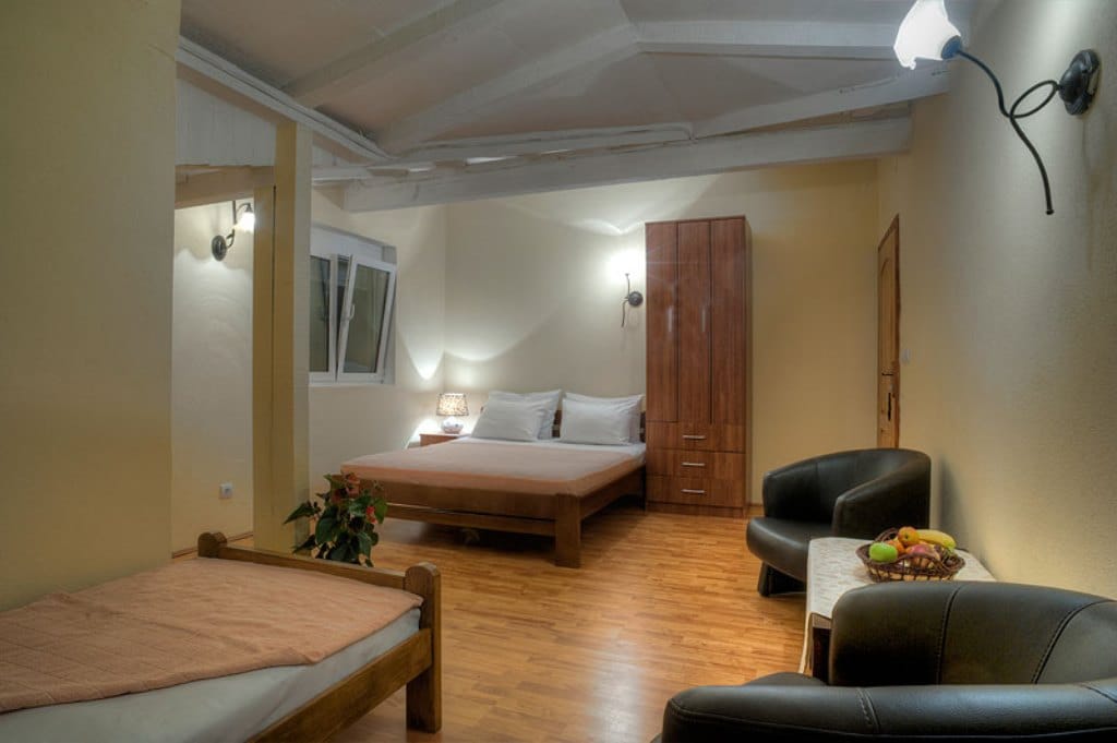 Cozy bedroom with a double bed and armchairs in a hotel, Buljarica, Montenegro: interior with wooden furniture.