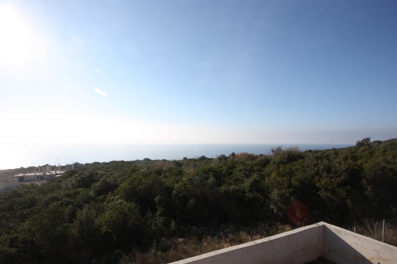 Panoramic view of the sea and green hills from a plot of land in the village of Krimovica, Montenegro.
