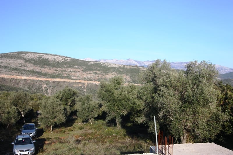 Land plot in Krimovica, Montenegro: panoramic mountain view, olive trees, and parking for cars.