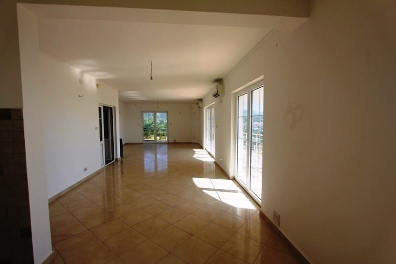 Spacious living room with panoramic windows and tiled floor in a villa in Dobra Voda, Montenegro.