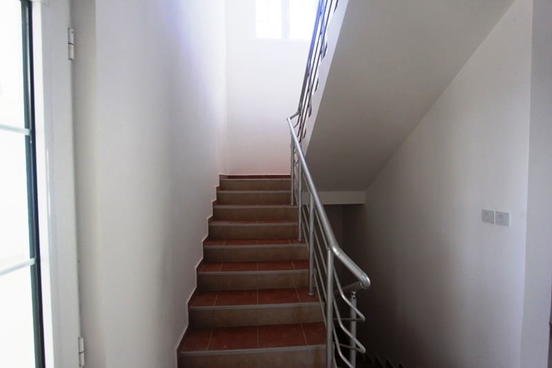 Staircase with tiled steps and metal railings in the interior of a villa in Dobra Voda, Montenegro.