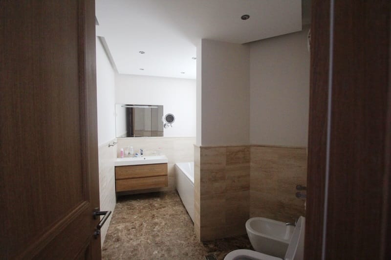 Modern bathroom with stone finishes, bathtub and bidet in a villa in Blizikuće, Montenegro.