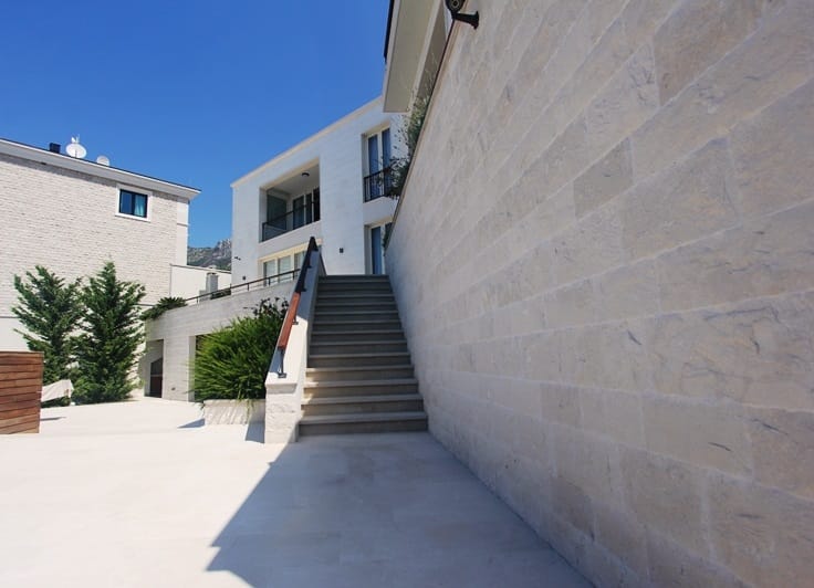 Modern villa in Blizikuće, Montenegro: stone facade finish, staircase, and landscaped grounds.