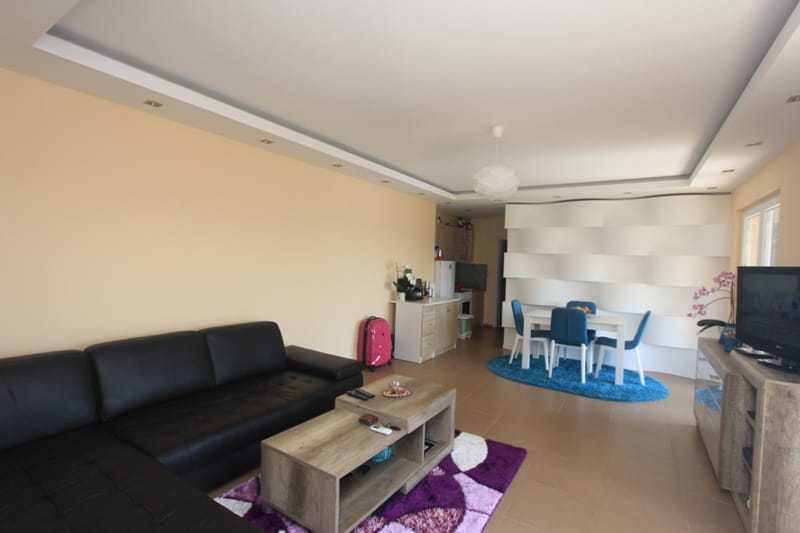 Living room with a black leather sofa and dining area in a house, Seoce, Montenegro: modern interior with wall decor.