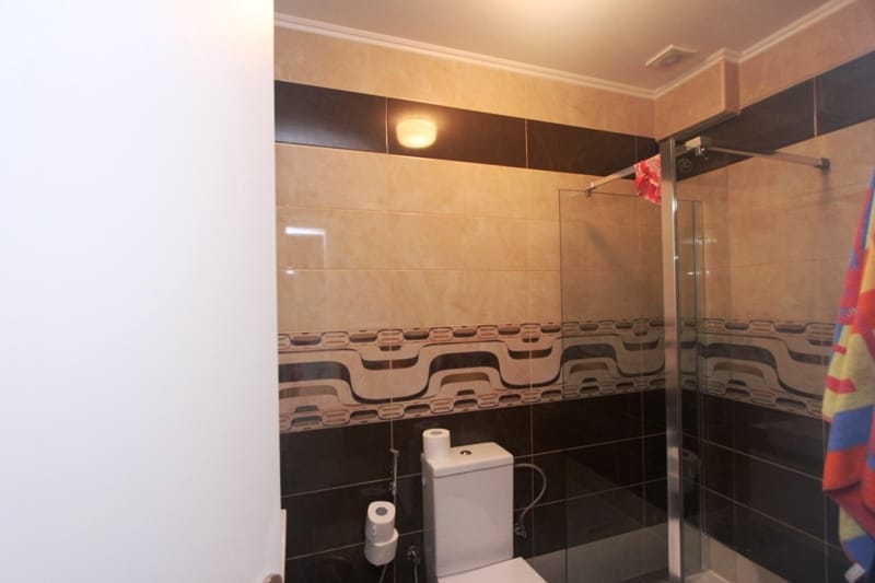 Bathroom in a house in Uteha, Montenegro: modern shower cabin and tile finishes in beige and brown tones.