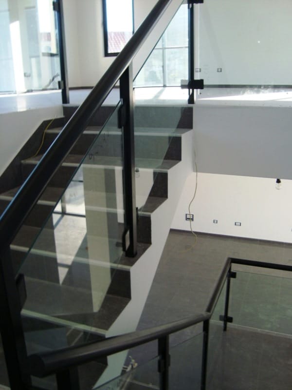 Modern staircase with black railings and glass balustrade in a commercial space, Baošići, Montenegro.