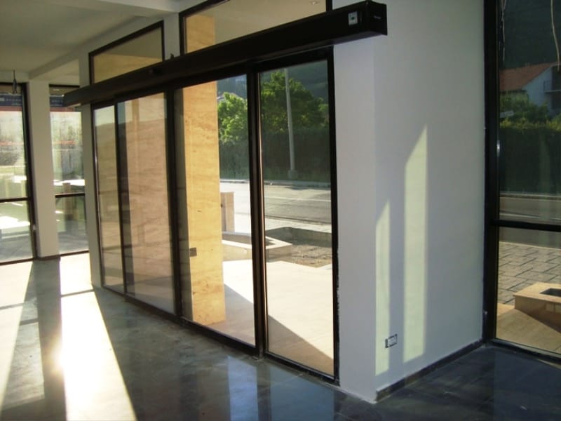Commercial premises in Baošići, Montenegro: panoramic glazing, sliding doors, and natural stone finishes.