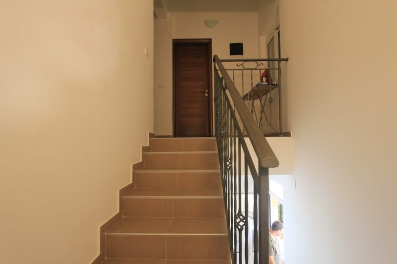 Staircase with wrought-iron railings and light finishes in the interior of a villa in Lepetani, Montenegro.