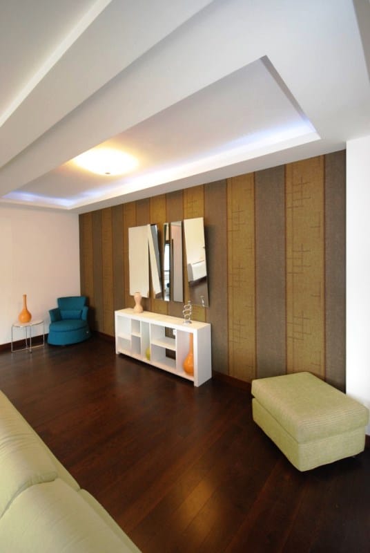 Modern living room in the Kostanica residential complex, Montenegro: designer wall finishes, dark parquet flooring, and stylish furniture.