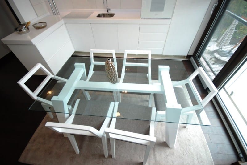 Modern kitchen with a glass table in a residential complex, Kostanica, Montenegro: stylish interior and view of the terrace.