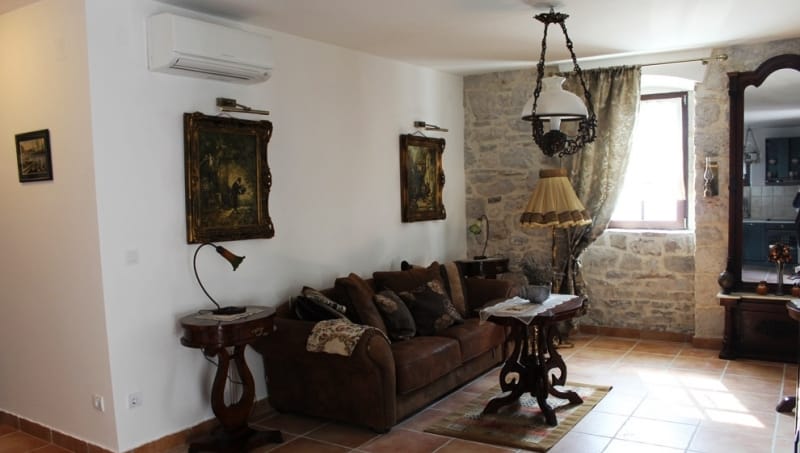 Living room in a house in Strp, Montenegro: vintage furniture, stone walls, antique details, and a cozy interior.