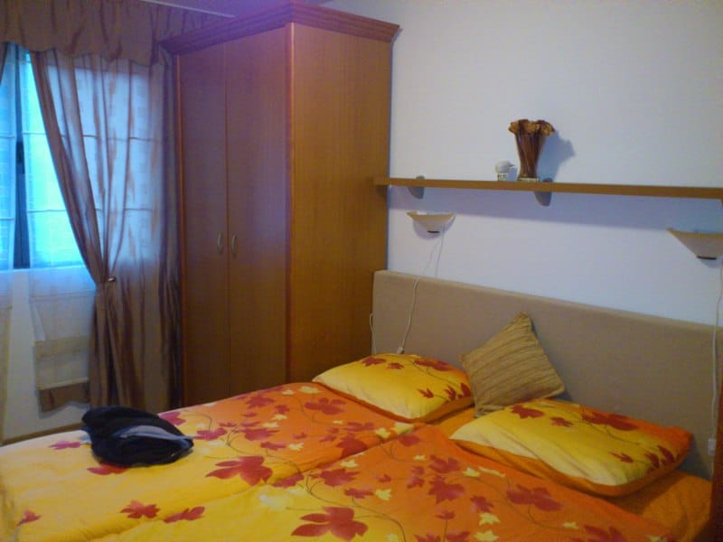 Cozy bedroom with a double bed and a wooden wardrobe in an apartment for sale, Pržno, Montenegro.