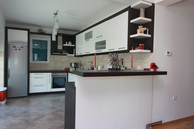 Modern kitchen with a breakfast bar and white cabinetry in a house for sale, Stoliv, Montenegro.