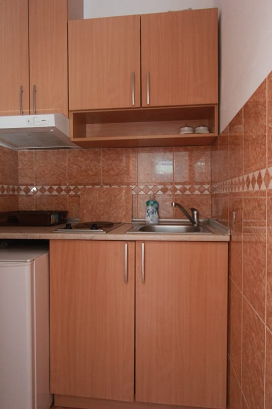 Compact kitchen with wooden cabinets and tile in a house for sale, Stoliv, Montenegro.