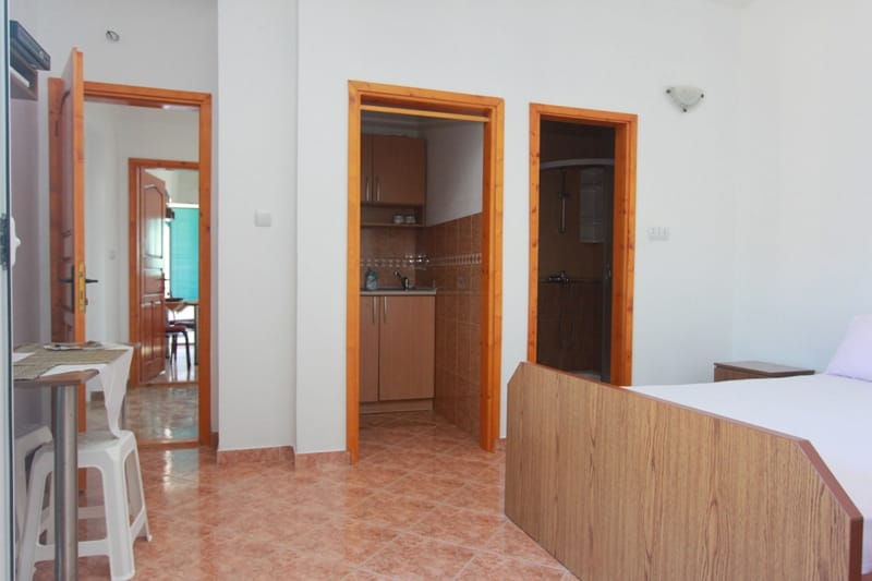 Bedroom with a double bed, kitchenette, and bathroom in a house for sale, Stoliv, Montenegro.