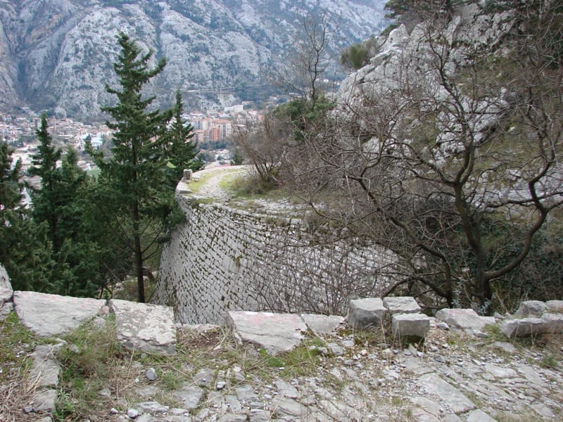 View of an old stone fortress wall and mountain landscape in Lepetani, Montenegro, panoramic view of the town and mountains.