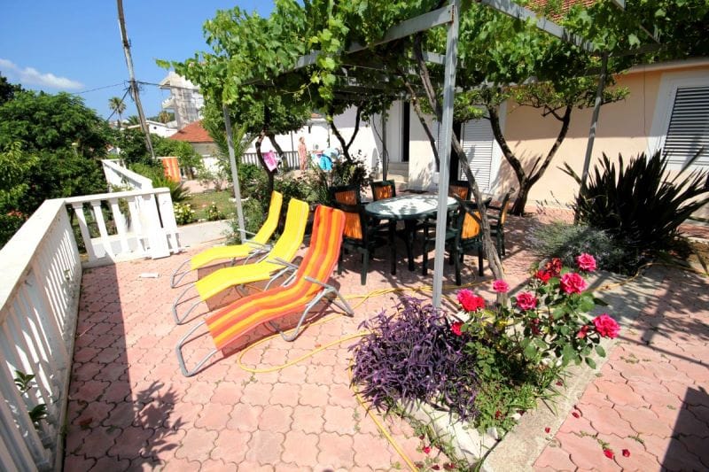 Cozy terrace with loungers and a dining area under a grapevine in a house, Đenovići, Montenegro.