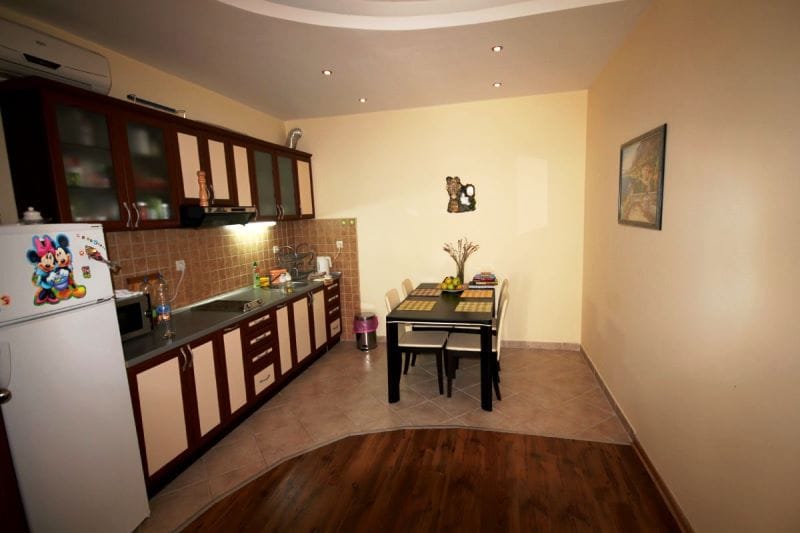 Kitchen with dining area in a house, Đenovići, Montenegro: dark wood cabinets, tile and laminate flooring.