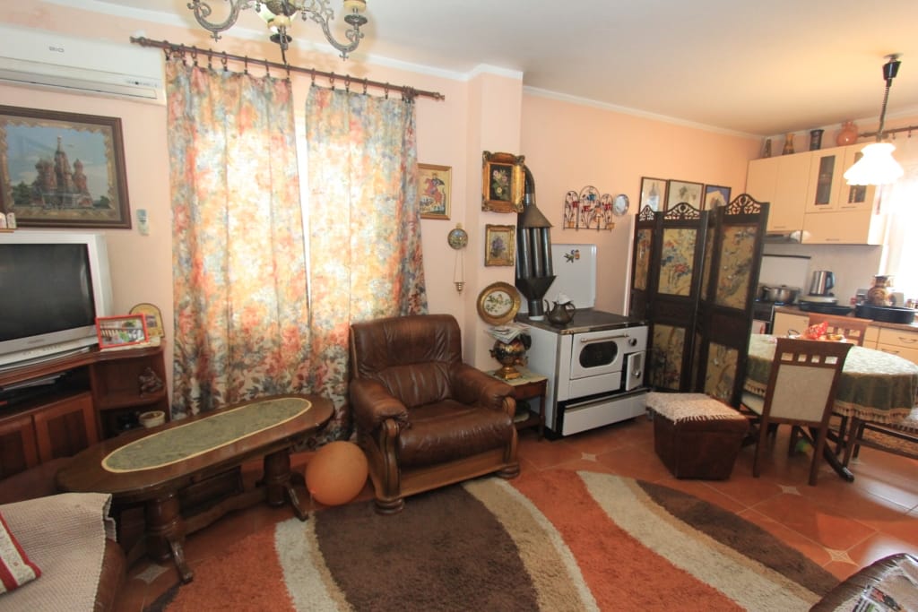 Living room in a house in Radanovići, Montenegro: leather armchair, wood-burning stove, dining area, and classic interior.