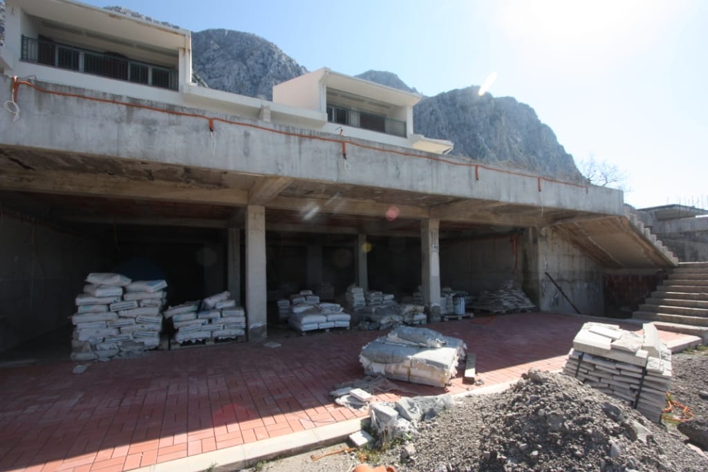 Villa under construction in Blizikuće, Montenegro: concrete structure, open tiled terrace, and building materials.