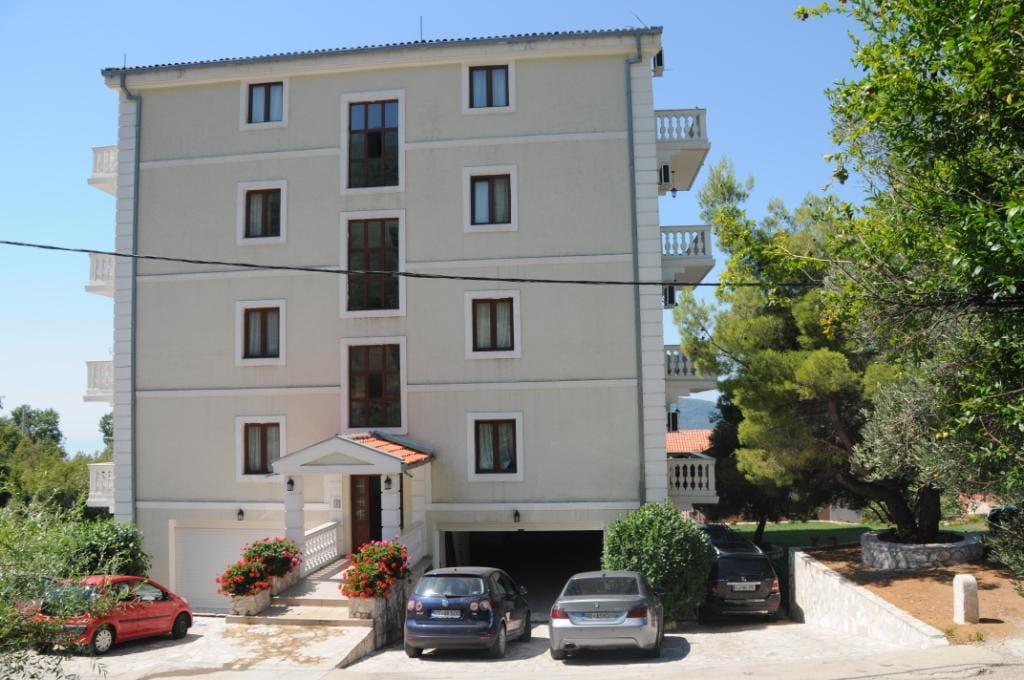 Four-story villa in Markovichi, Montenegro: building facade, parking area, and surrounding grounds with trees.