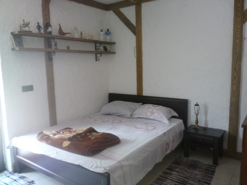 Bedroom with a double bed and wooden beams in a villa in Bigovo, Montenegro: rustic-style interior.