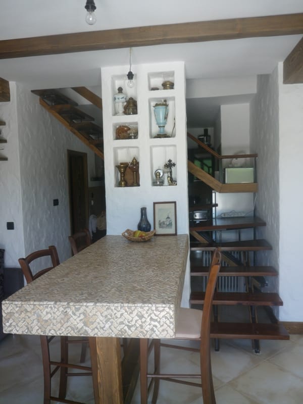Kitchen interior in a villa in Bigovo, Montenegro: a bar counter, wooden staircase, and decorative wall niches.