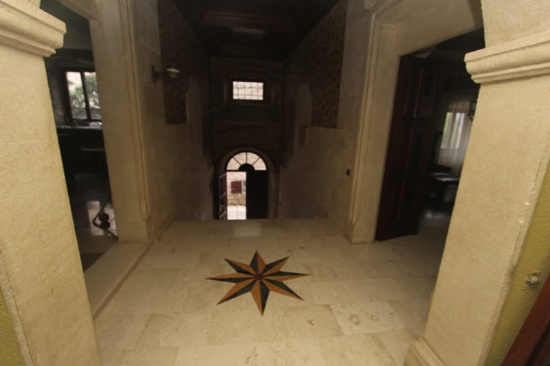 Villa interior in Prčanj, Montenegro: stone arches, marble floor with star mosaic, and antique hall finishes.