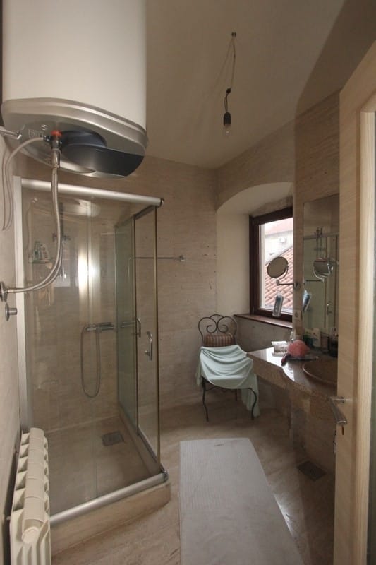 Bathroom in a villa in Prčanj, Montenegro: shower cabin, stone finishes, sink, and a window with a view.