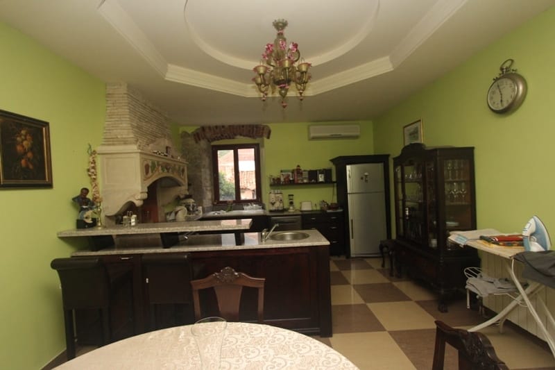 Kitchen with a bar counter and vintage furniture in a villa in Prčanj, Montenegro. Interior with stone finishes and a chandelier.