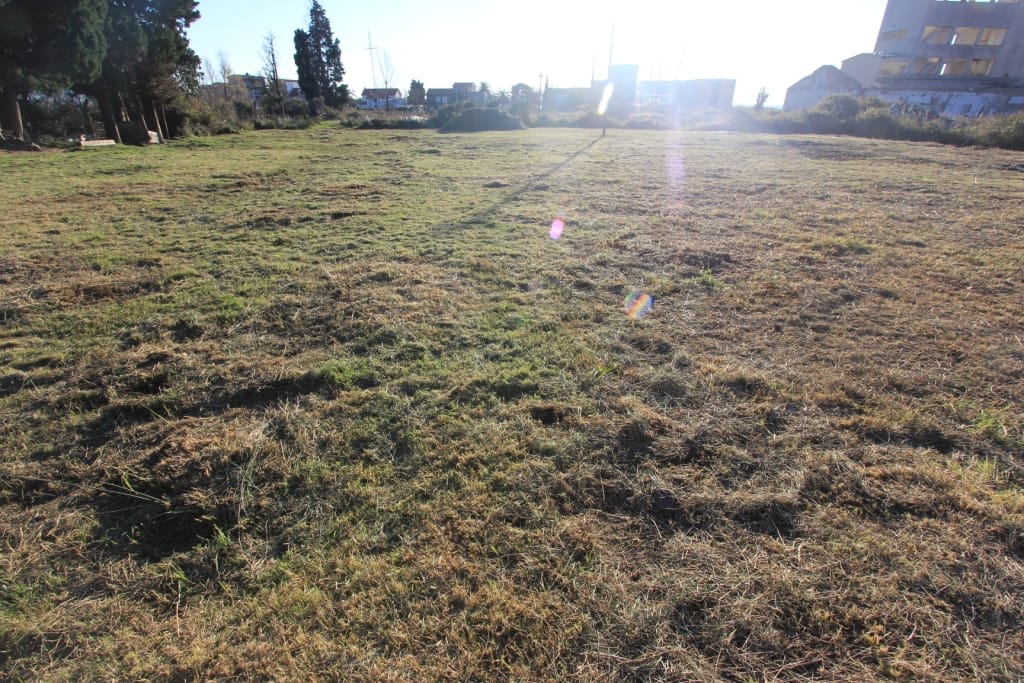 Flat building plot in Buljarica, Montenegro: open grassy land with views of the surrounding area.